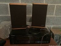 Pioneer SX-2300 stereo receiver with two Advent speakers on top, speaker wires placed on receiver.