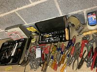 Overview of assorted hand tools, screwdrivers, pliers, scissors, hammer, tape measures, and socket sets.