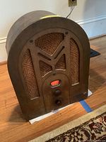 Full view of vintage RCA Victor radio with wooden housing, fabric speaker grills, and arched front design.