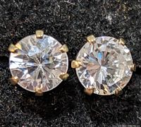 Front close-up view of the pair of 10K yellow gold stud earrings with clear cubic zirconia stones.