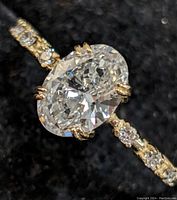 Front view of ring showing oval diamond center and accent stones