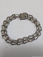 Image showing the full length of the silver linked chain bracelet with clasp closed, displaying the double-strand style links and polished finish.