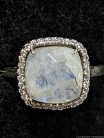 Close-up of the top view showing the cushion-cut moonstone with halo setting on a sterling silver band.