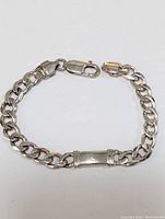 Sterling silver bracelet displayed fully closed, showing curb link chain and lobster clasp.