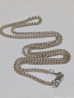 Full layed out view of the sterling silver chain exhibiting the chain style and condition.