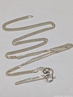 Full view of the sterling silver chain laid out flat showing clasp and length.