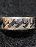 Close-up view of the sterling silver ring with visible zigzag design and polished finish.