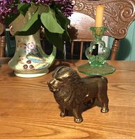 Front view of the bronze-finished cast iron lion coin bank showing detailed mane and facial expression.