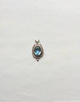 Front view of the antique sterling silver pendant with oval blue topaz stone showing detailed silver work.