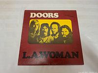 Front cover of L.A. Woman vinyl album showing The Doors band members and album title.