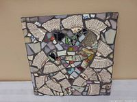 Full view of the 12x12 inch square mosaic featuring a heart formed from broken crockery pieces with patterned white pieces surrounding it.