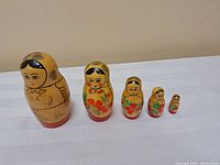 Full view of the five wooden nesting dolls arranged in descending size order.