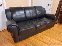 Front-left angle view showing three seat cushions and rolled arms