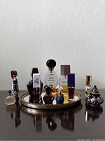 Full view of the perfume lot displayed on a mirrored tray, showing a variety of bottles of different shapes, sizes, and colors