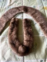 Two mink fur collars laid on floral patterned fabric, showing overall condition and shape.