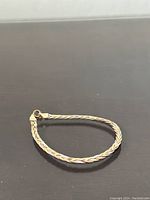 Full view of the braided mixed-metal bracelet laid flat