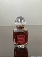 Frontal view of the vintage perfume bottle showing the label clearly with bottle filled with brown liquid and glass stopper on top.