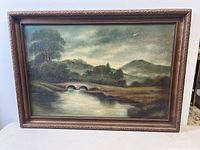 Front view of the oil painting showing the bridge over water, trees, and distant mountains.