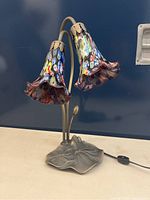 Decorative two-shade lamp with colorful flower-shaped glass shades and metal leaf base