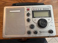 Front view of Sansui S350 radio showing controls, speaker, digital display, and tuning knob.