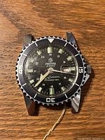 Front view of watch case showing black dial, luminous markers and rotating bezel