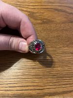 Front view of the class ring showing the red gemstone and overall design.