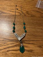 Photo of Victorian-style necklace showing green polished stone pendant, rhinestone centerpiece, green beads on chain