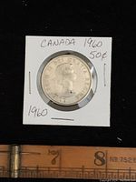 Obverse side of 1960 Canada 50 cent coin showing Queen Elizabeth II portrait and inscription.
