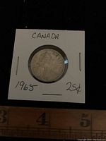 Obverse side of the 1965 Canadian quarter, showing Queen Elizabeth II profile and handwritten labels on holder.