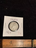 Obverse side of 1965 Canada quarter coin featuring Queen Elizabeth II's profile.