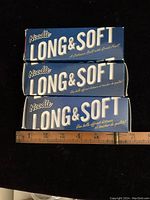 Three blue and white sleeves of Noodle Long & Soft golf balls stacked, showing brand and product name on box.