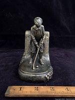 Front view of the golfer bookend showing the golfer in a putting stance with club and ball.