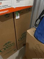 Cardboard box labeled Oasis with palm tree logo, showing part of the cooler packaging.