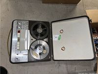 Full view of the Salute reel-to-reel tape recorder in open hard case showing both tape reels and control panel.