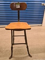 Front view of the vintage wooden chair with metal frame showing wooden seat and backrest.