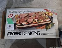 Photo of the top of the box showing the Pyrex Designs branding and image of the oblong baking dish with food inside.