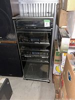 Full view of the vintage JVC stereo system with glass door closed showing multiple components in cabinet.