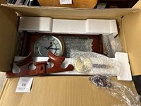 Cherry wood grandfather wall clock in box with styrofoam protection and bubble wrap covering parts.