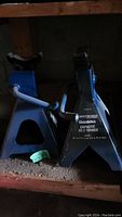 Two blue car jack stands with label showing 2 tonnes capacity and details.