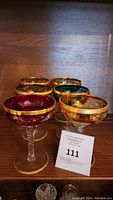 Set of 6 jeweled champagne glasses in red, green, amber with gold floral patterns and jeweled decoration.