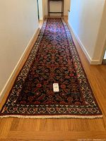 Full-length view of runner in hallway showing floral pattern and fringe at near end