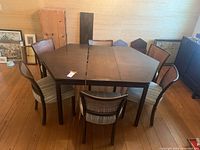 Photo of the complete hexagonal dining table with six chairs surrounding it, showing the table top and chair arrangement.