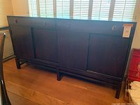 Front view of full sideboard showing two drawers with wood pulls and four sliding doors.