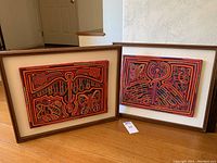 Two framed textile art pieces side by side leaning on floor