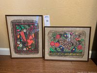 Pair of complementary framed indigenous Mexican art paintings displayed side by side showing frame size and overall presentation.