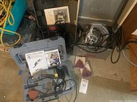 Porter Cable saw, Dremel Multi-Max in case with manuals and sanding pads, Craftsman router all placed on floor