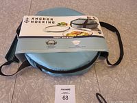 Image of the light blue insulated case with product label showing Anchor Hocking Bake N Take branding and usage information.