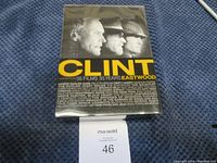 Box set of 35 Clint Eastwood films on DVD, sealed in shrink wrap on blue cloth background.