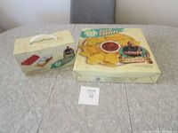 Two boxed serving sets on table - one taco serving kit and one chip and dip serving set