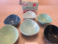 Top-down view of all six ice cream bowls arranged around the original packaging box with label visible